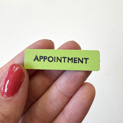 A small rectangular lime green magnet with the word &