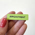 A small rectangular lime green magnet with the word &